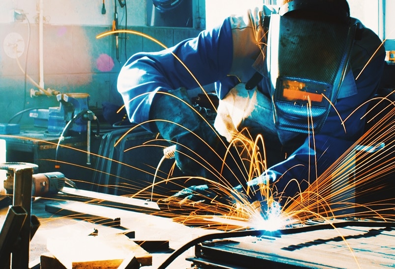 Person in einer Werkstatt am schweissen