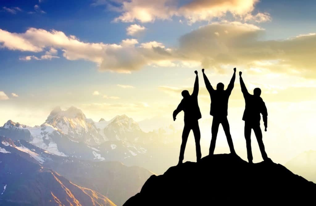 3 Personen auf dem Gipfel eines Berger