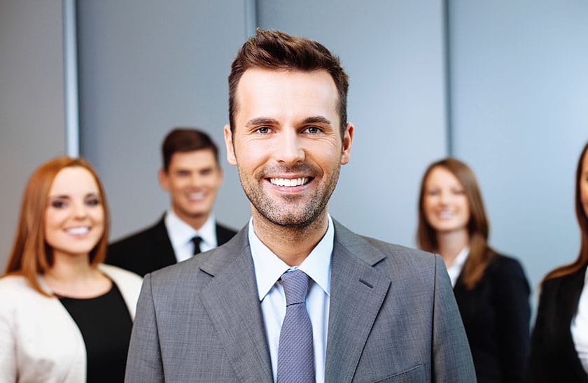 Anzugträger mit vier Personen im Hintergrund