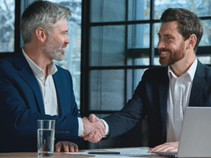 benefitIMPACT Verkaufstraining B2B_Verkäufer bzw. Berater und Kunden schütteln sich lächelnd die Hand