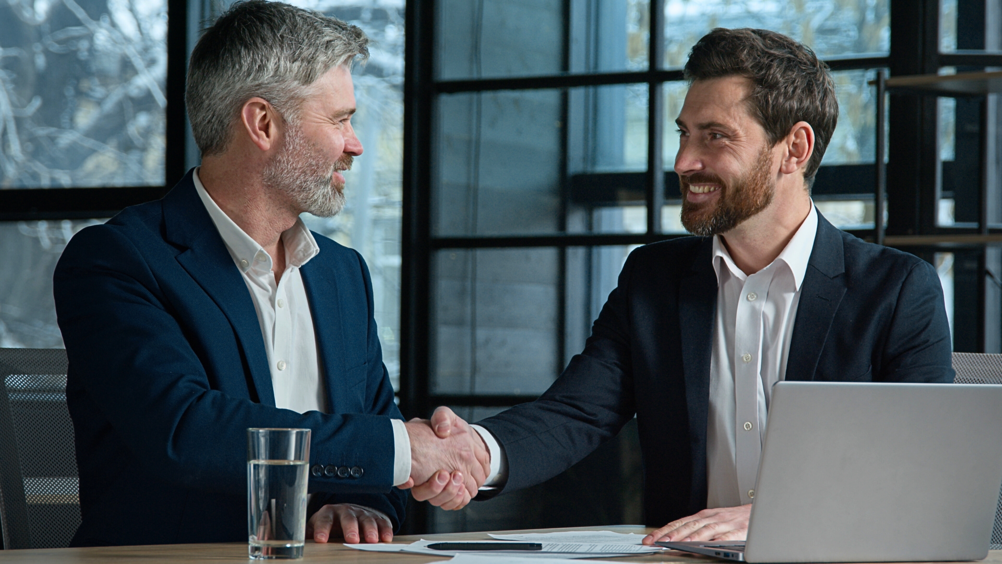 B2B-Kunde schüttelt Berater lächelnd die Hand