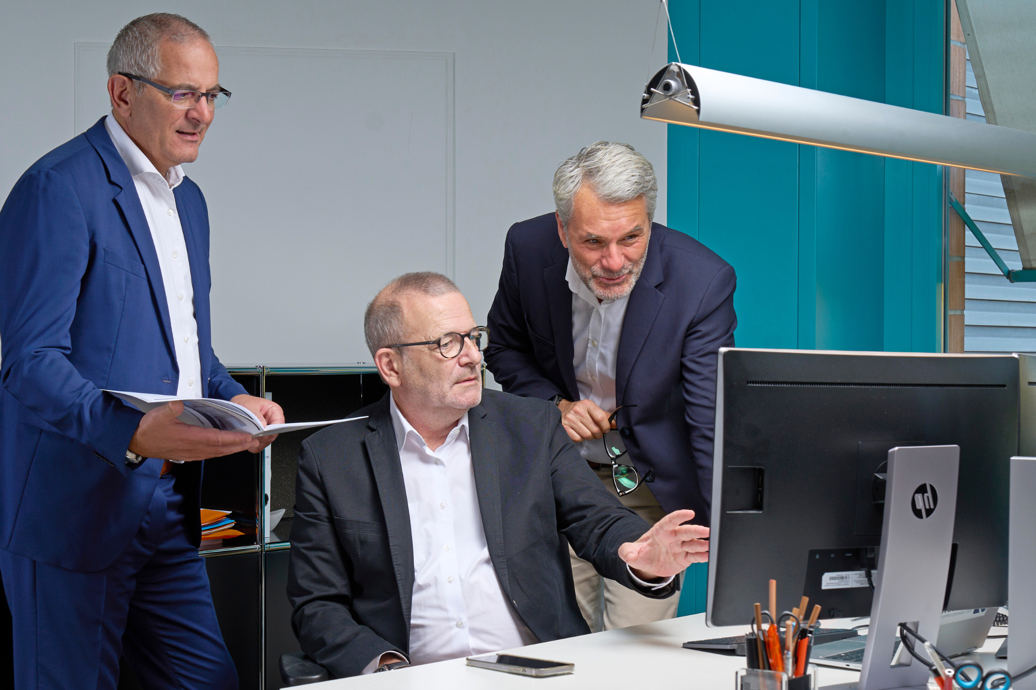 benefitIMPACT Trainer Olivier Égelé, Jean-Christophe Nigon und Valdemar Duarte im Austausch am Computer