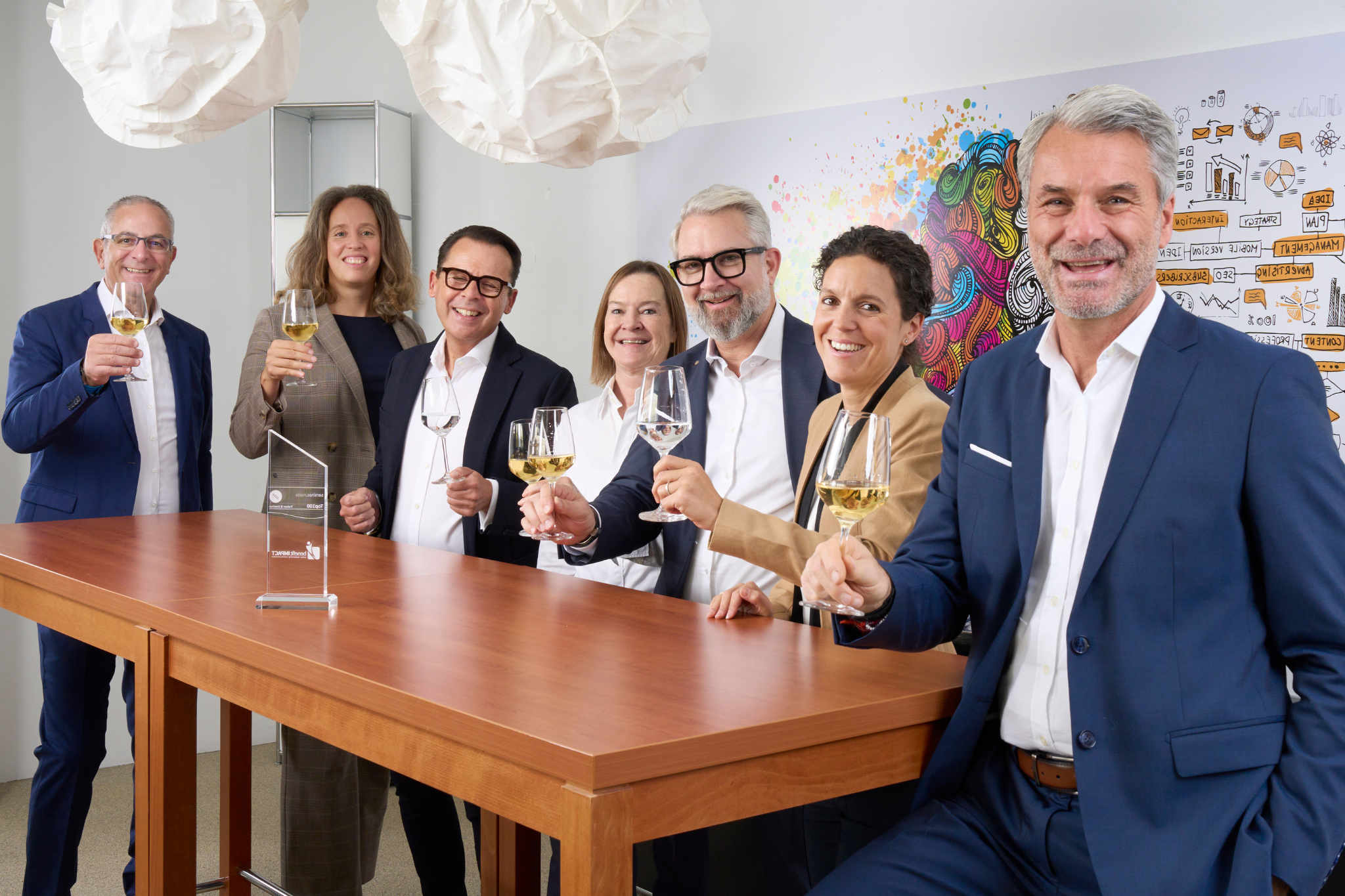 Das benefitIMPACT Team stösst auf den gemeinsamen Erfolg an